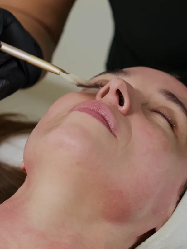 A client receiving a facial treatment with a brush
