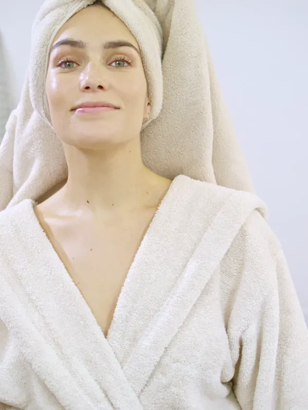 A smiling woman in a robe after her skincare